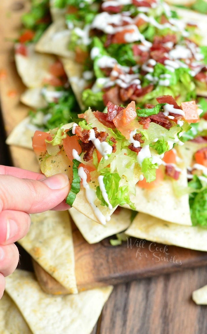 holding a BLT Nachos on a tortilla Chips