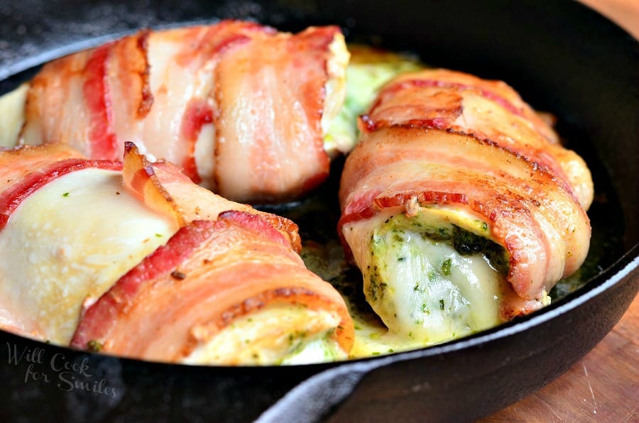 bacon wrapped chicken breast with cheese in a cast iron pan 