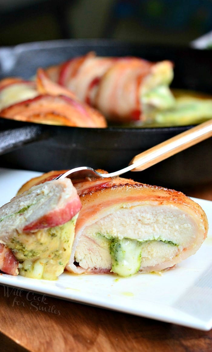 bacon wrapped chicken breast with cheese in a cast iron pan 