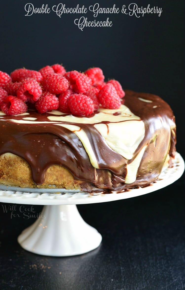 Double Chocolate Ganache and Raspberry Cheesecake with raspberries on top on a cake stand 
