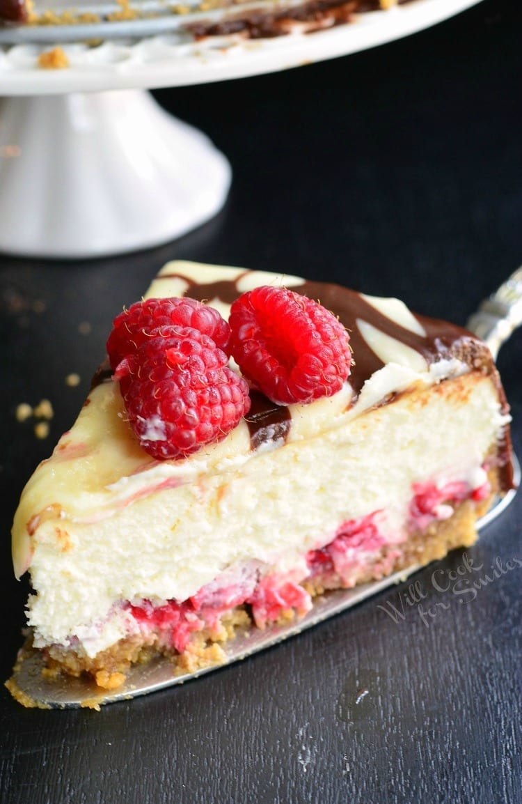 Slice of Double Chocolate Ganache and Raspberry Cheesecake with raspberry on top on a pie spatula 