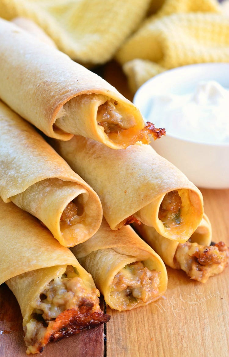 Jalapeño Sausage and Cheese Taquitos stacked on a cutting board 