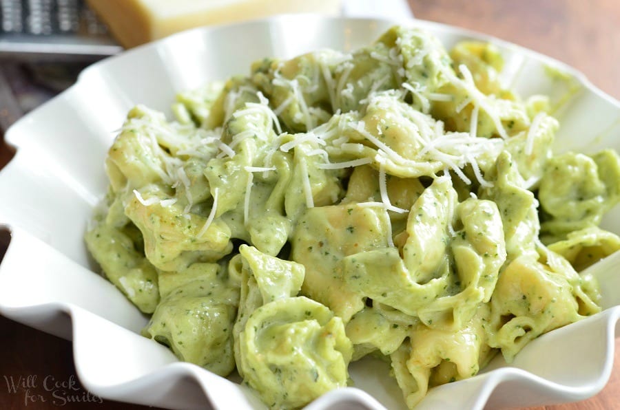 Pesto Alfredo Tortellini in a serving bowl with cheese on top 