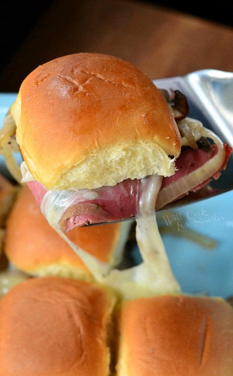 lifting Baked Corned Beef Sliders with a metal spatula 
