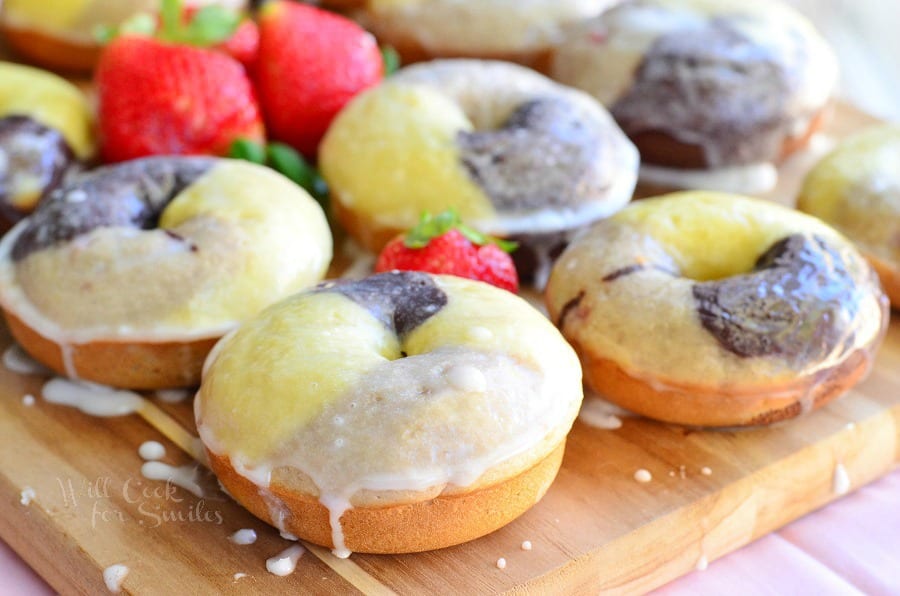 Neapolitan Glazed Doughnuts on a cookie sheet with strawberries
