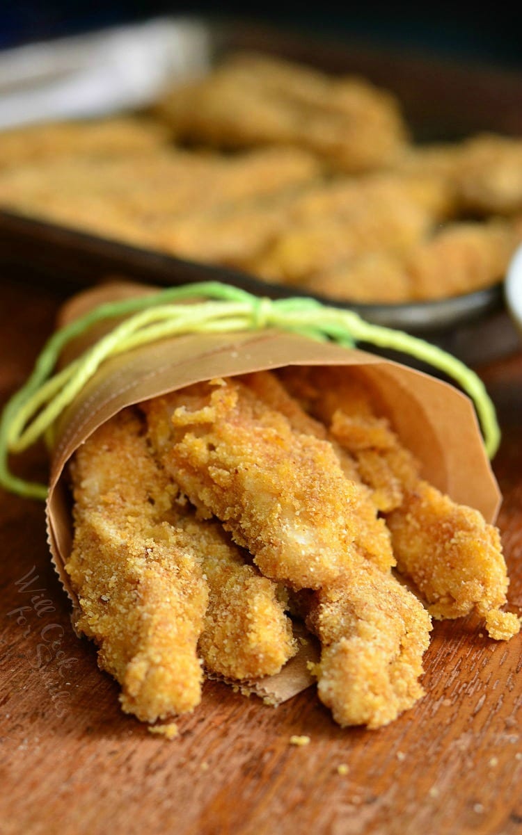 Baked Chicken Fries  in parchment paper on a cutting board 