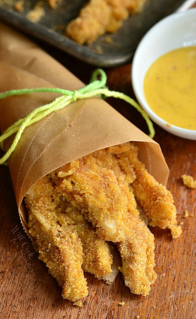 Baked Chicken Fries wrapped in butcher paper with a bowl of honey mustard to the right 