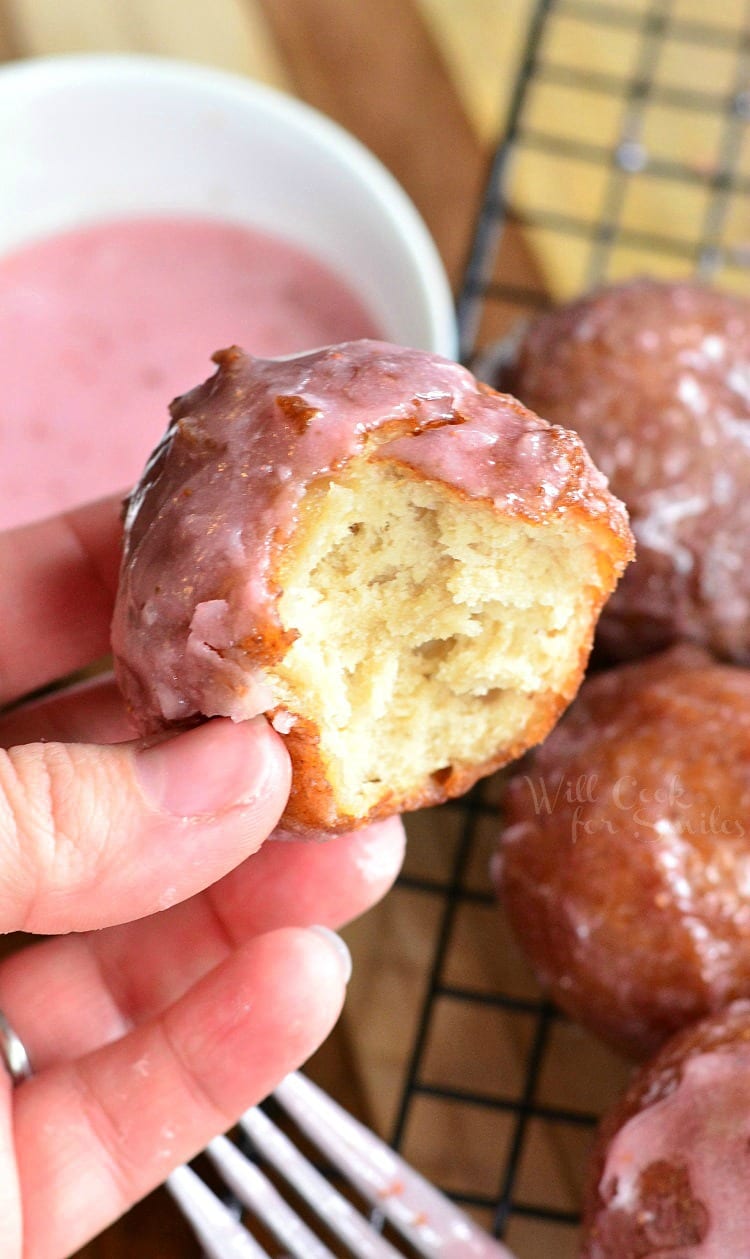 Glazed Strawberry Ricotta Doughnuts with a bite taken out of it 