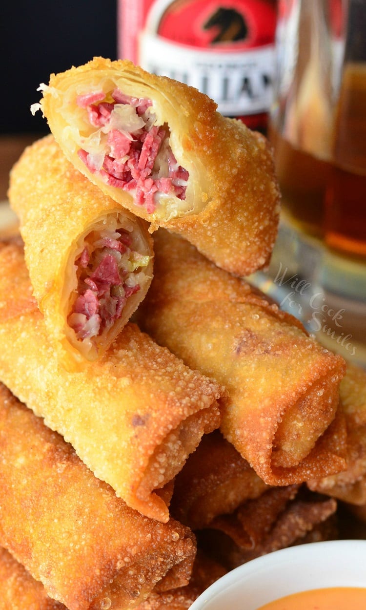 Reuben Egg Rolls staked up and the top one cut in half 