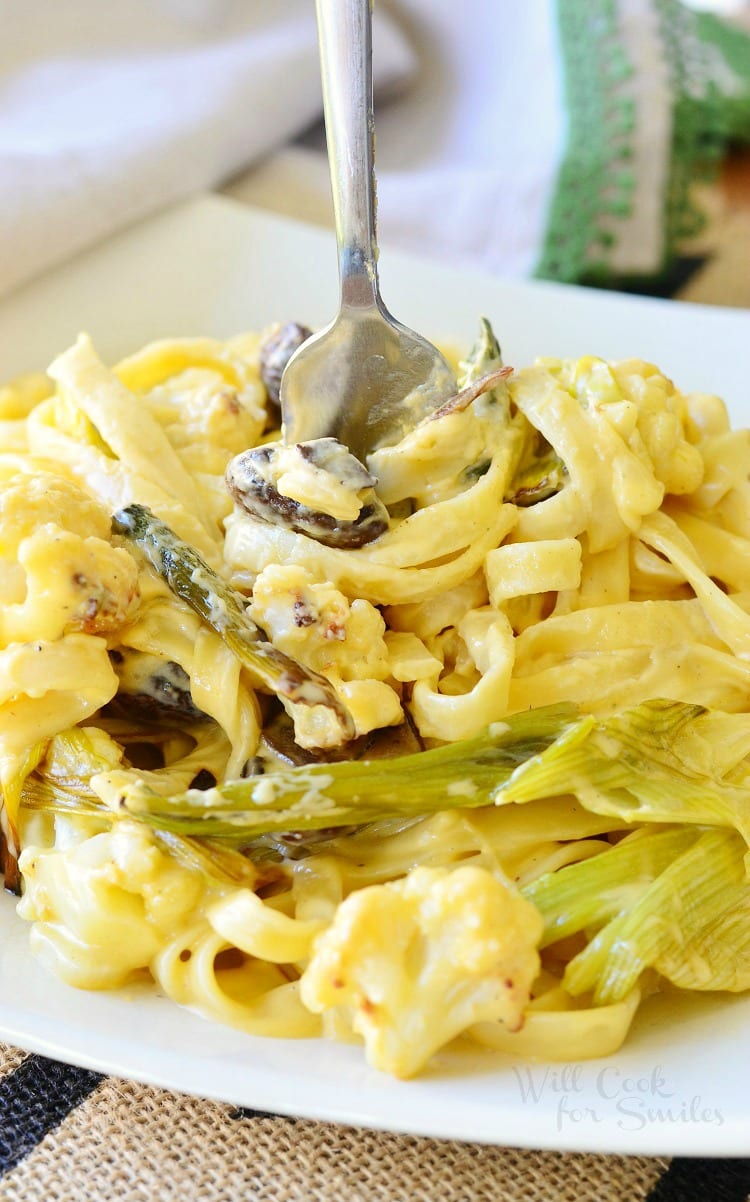 Cauliflower, Leek and Mushroom, with Fettuccine noodles in Garlic Cheese Sauce in a bowl with a fork in the middle 