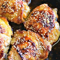 Skillet with sesame roasted chicken thighs as viewed from above
