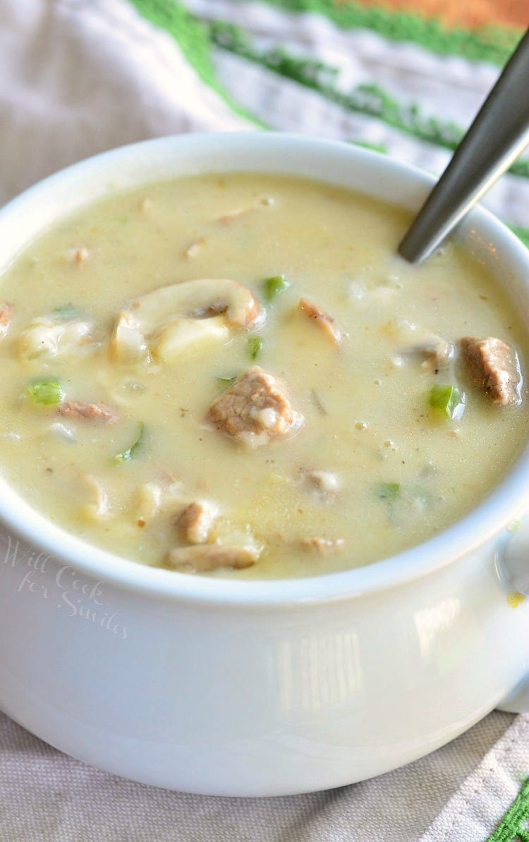 Steak and Cheese Soup in a white soup bowl with a spoon in it 