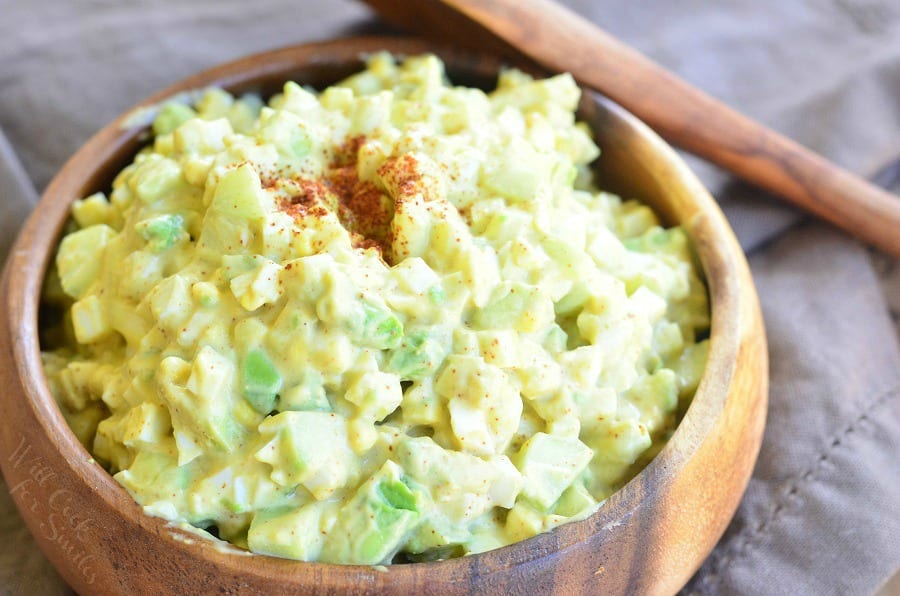 top view photo of Avocado Cucumber Egg Salad in a wood bowl with a wooden spoon 