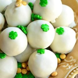 Baileys cookie dough truffles piled onto a decorative golden yellow plate with st patty's day candies sprinkles around them as shown from above