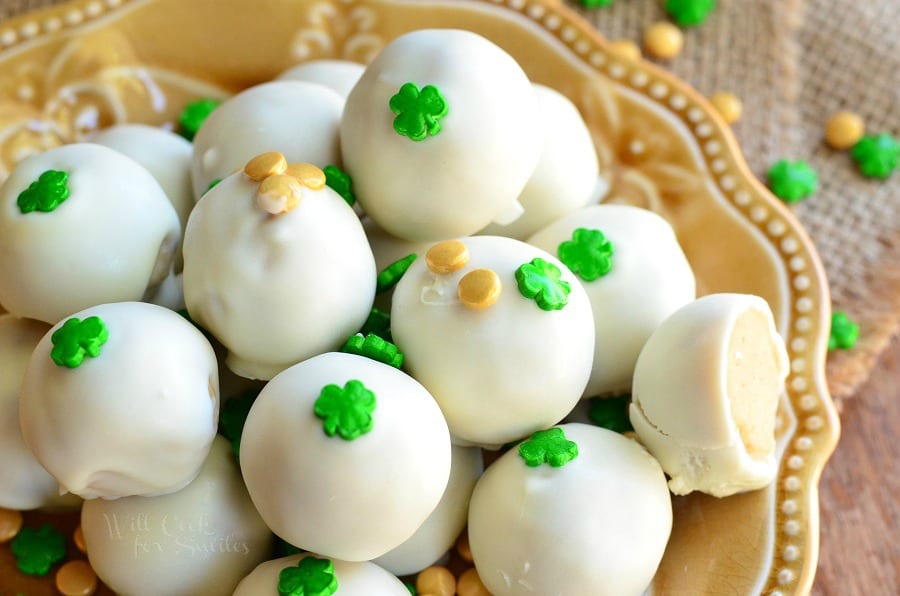top view photo of Bailey's Cookie Dough Truffles with shamrock candy on top on a yellow plate 