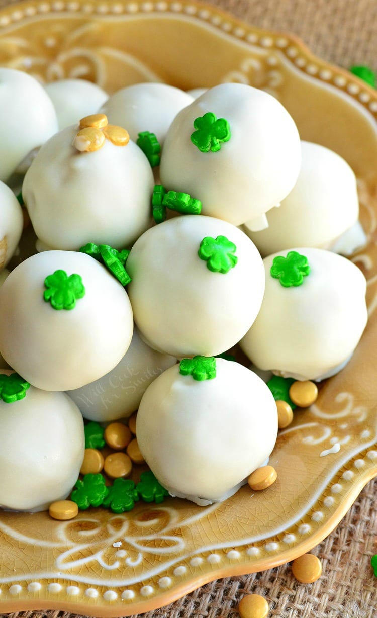 Bailey's Cookie Dough Truffles with shamrock candy on top on a yellow plate 