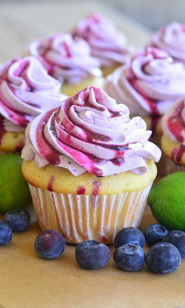 key lime cupcake with blueberry frosting and blueberries around the cupcake.