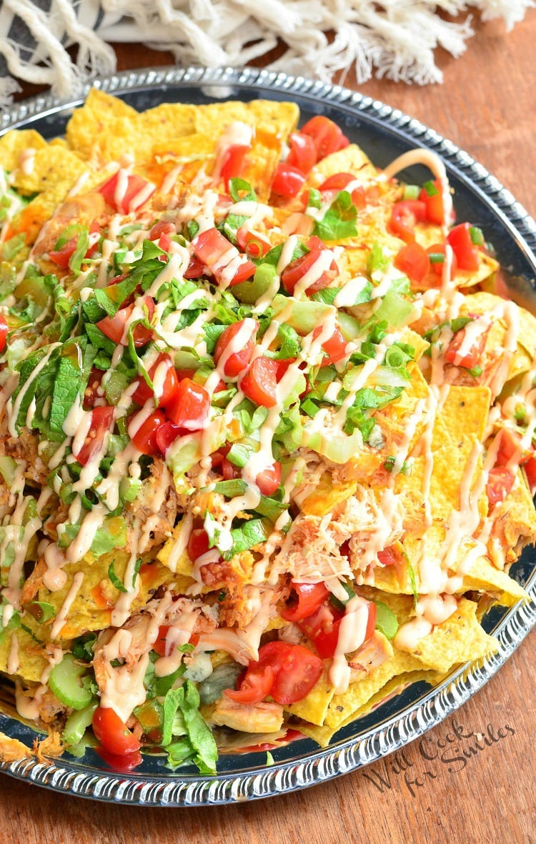 top view Buffalo Chicken Nachos on a metal serving plater on a table 