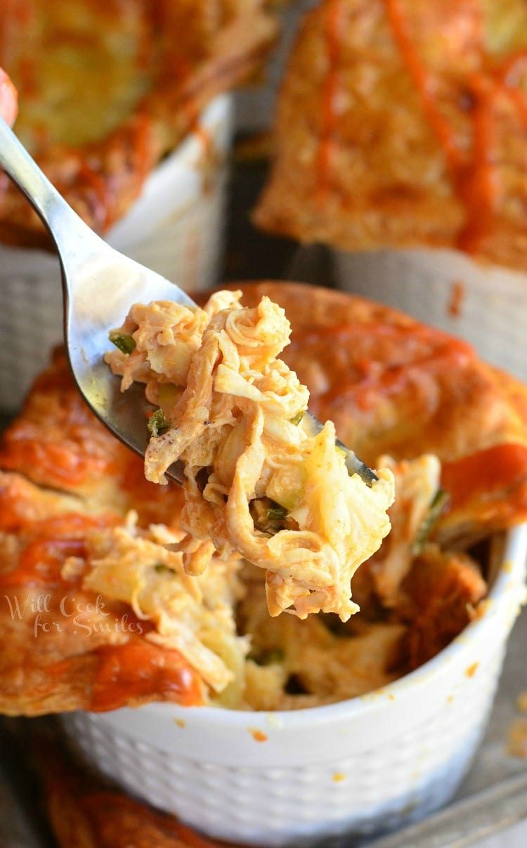 Buffalo Chicken Pot Pies in ramekin's with a fork lifting some out 