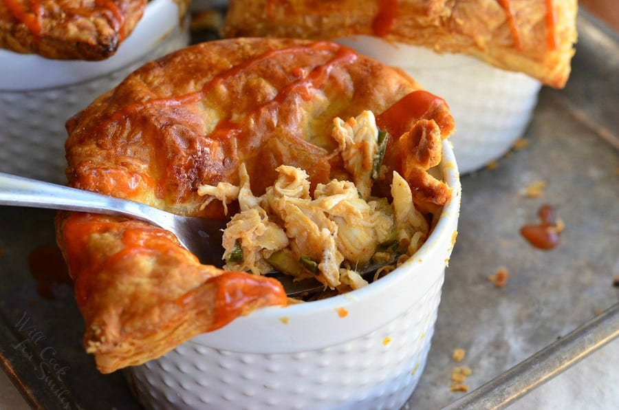 Buffalo Chicken Pot Pies in ramekin's and a fork lifting some out 