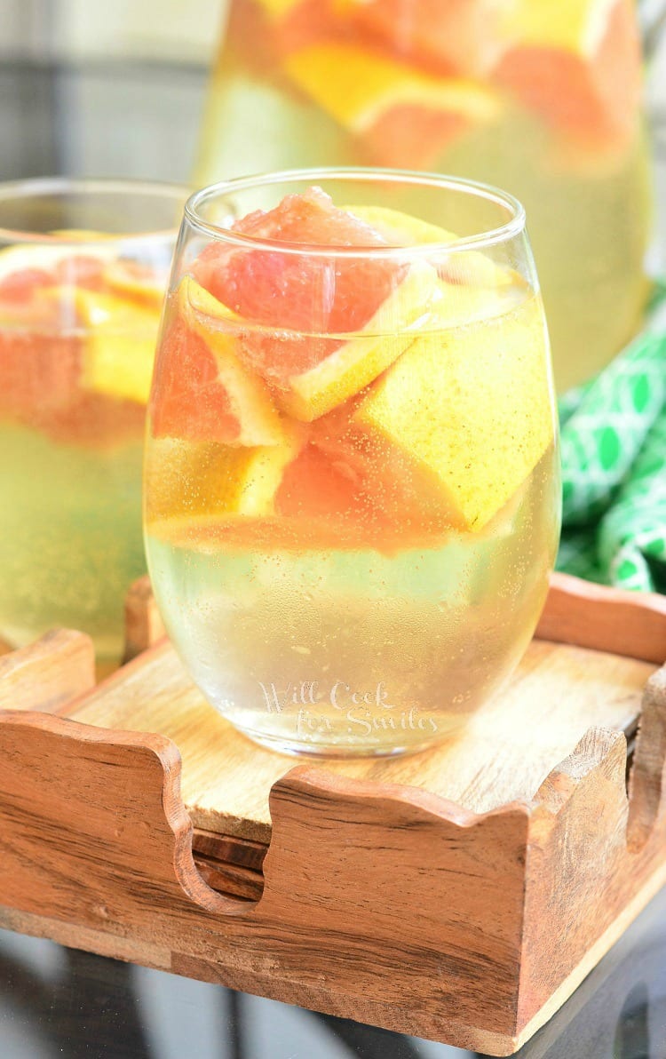 Fresh Grapefruit Sangria with grapefruit slices in a stemless wine glass on wood coasters 