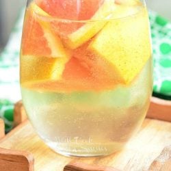 a wine glass with sangria and cut up grapefruit.