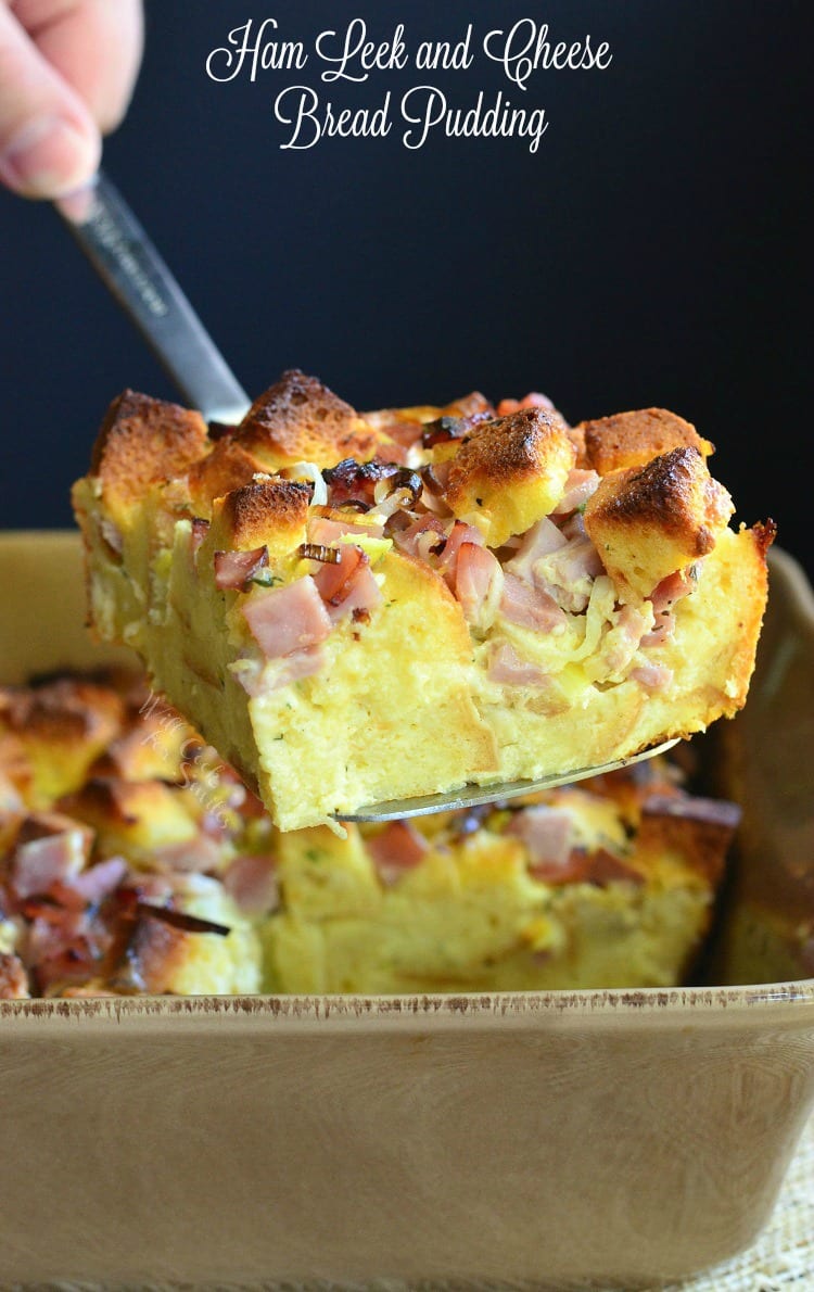 Ham Leek and Cheese Bread Pudding being lifted out of casserole dish with a spatula 