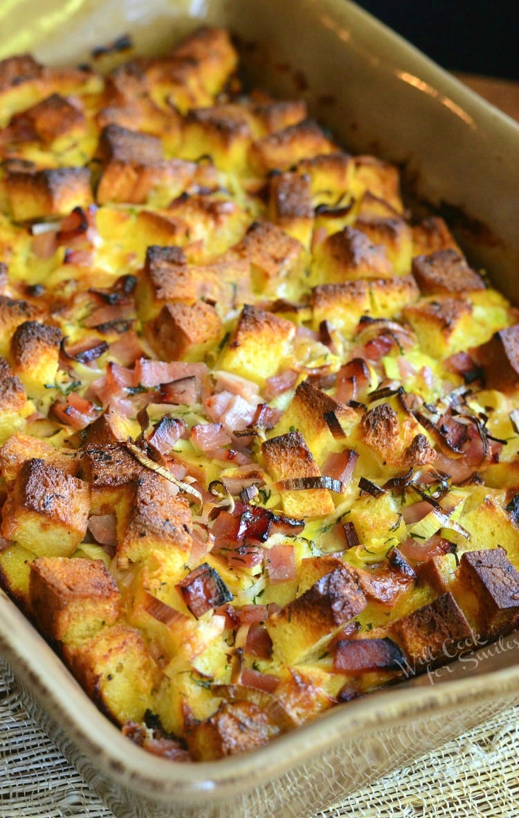 Ham Leek and Cheese Bread Pudding being lifted out of a baking pan