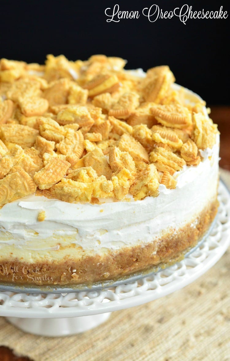 Lemon Oreo Cheesecake with crushed cookies on top on a cake stand 