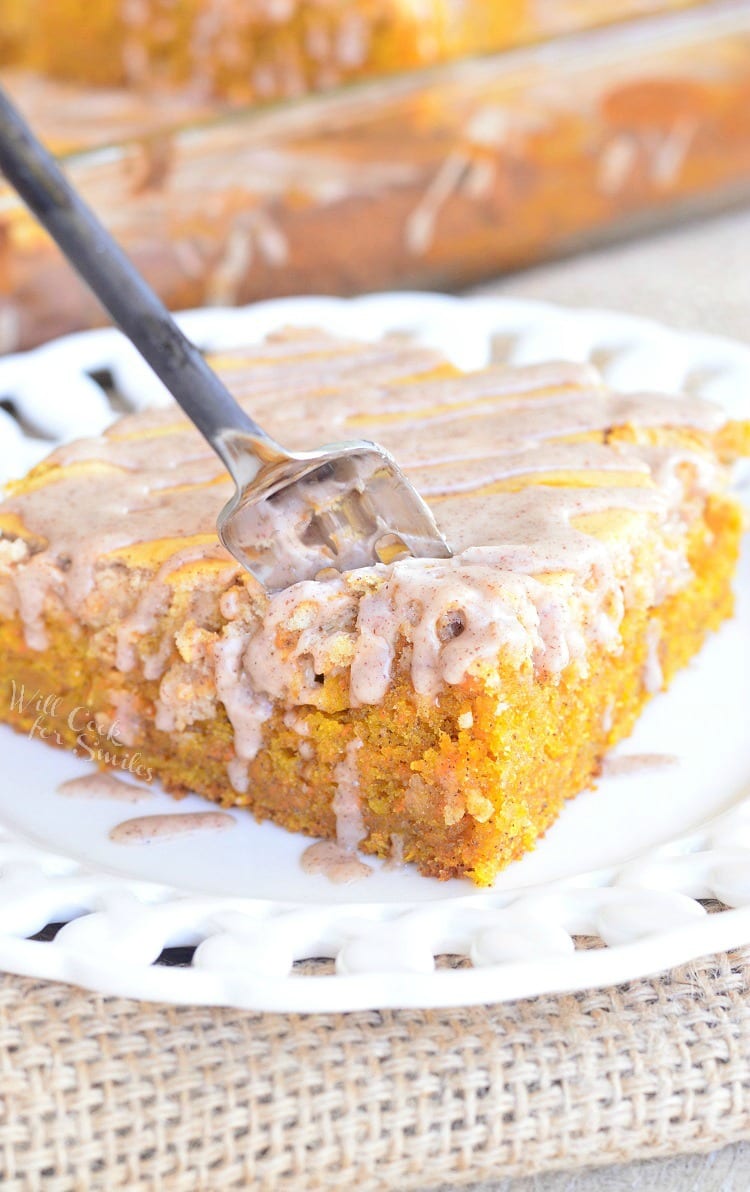 Spiced Cheesecake Swirled Carrot Cake on a white plate with a fork in it 