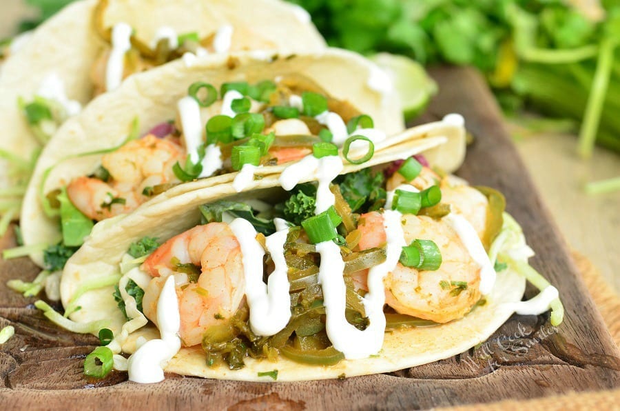 Tequila Lime Shrimp Tacos with sour cream and green onions on top 