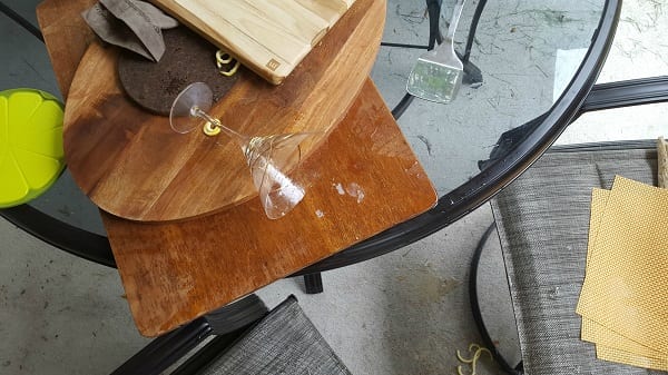 top view photo of Martini glass knocked over on a stack of wood cutting boards 