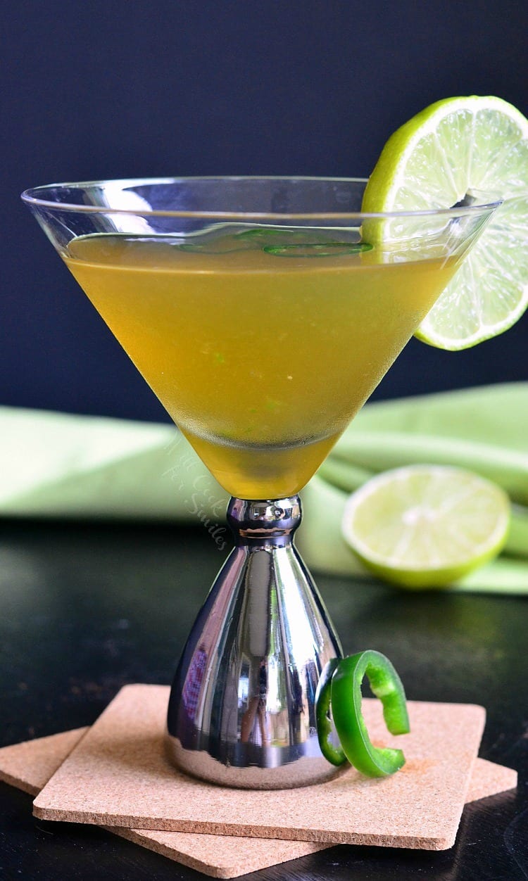 Jalapeno Margatini in a martini glass with 3 jalapenos and a lime 