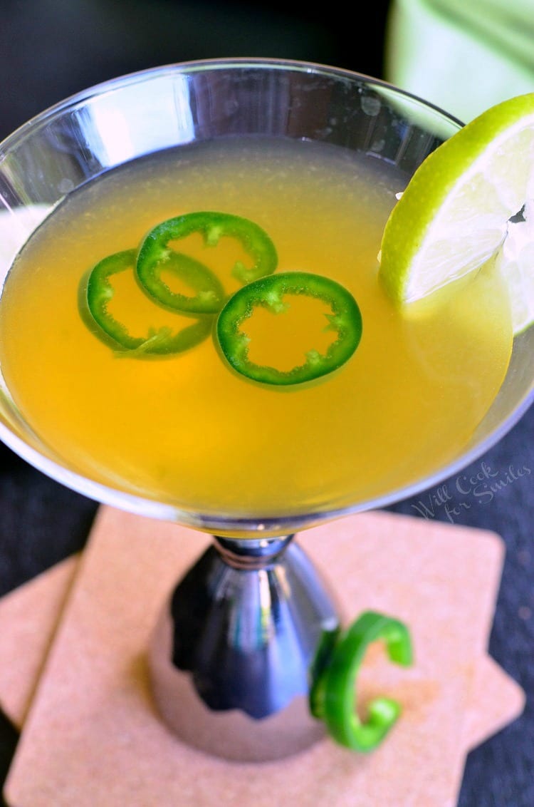 top view Jalapeno Margatini in a martini glass with 3 jalapenos and a lime 