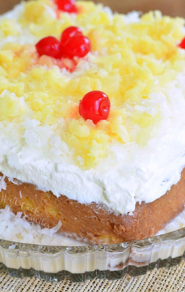 Tres Leches Cake with white coconut frosting, pineapple and cherries on top 