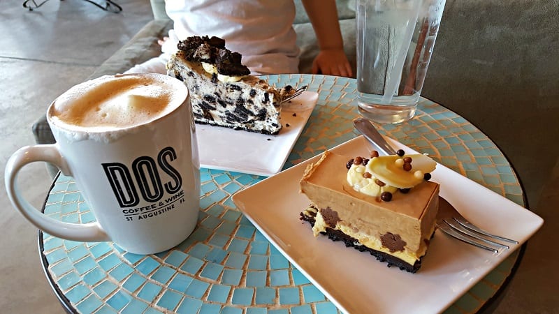 2 pieces of cake on a table with a coffee cup with a coffee in it 