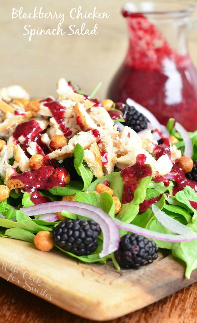 Blackberry Chicken Spinach Salad with Blackberry Poppy Seed Vinaigrette, blackberries, chickpeas, and red onions with salad dressing in the background 