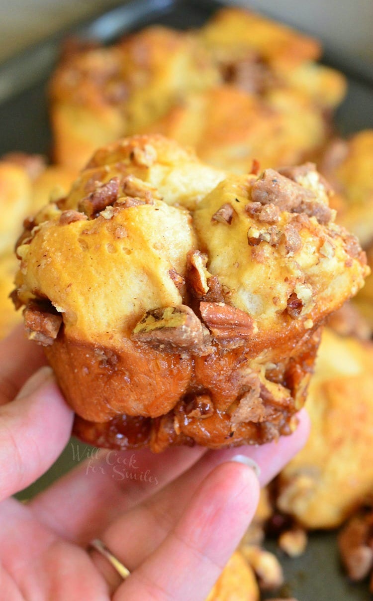 holding a Butter Pecan Pull-Apart Biscuit Muffins with candied pecans 