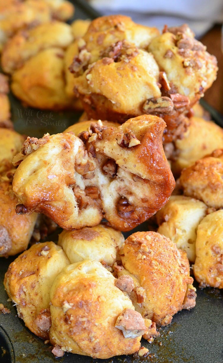 butter pecan pull apart biscuits stacked up on a baking sheet,