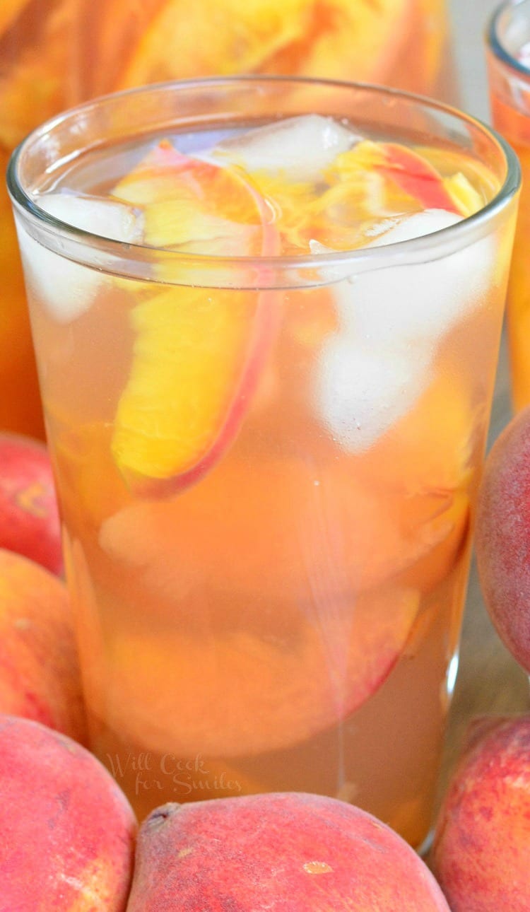 close view of peach iced tea made with green tea and fresh peaches in a glass.