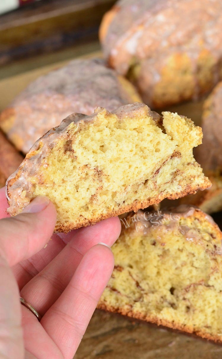 holding a piece of Glazed Cinnamon Swirled Scones 