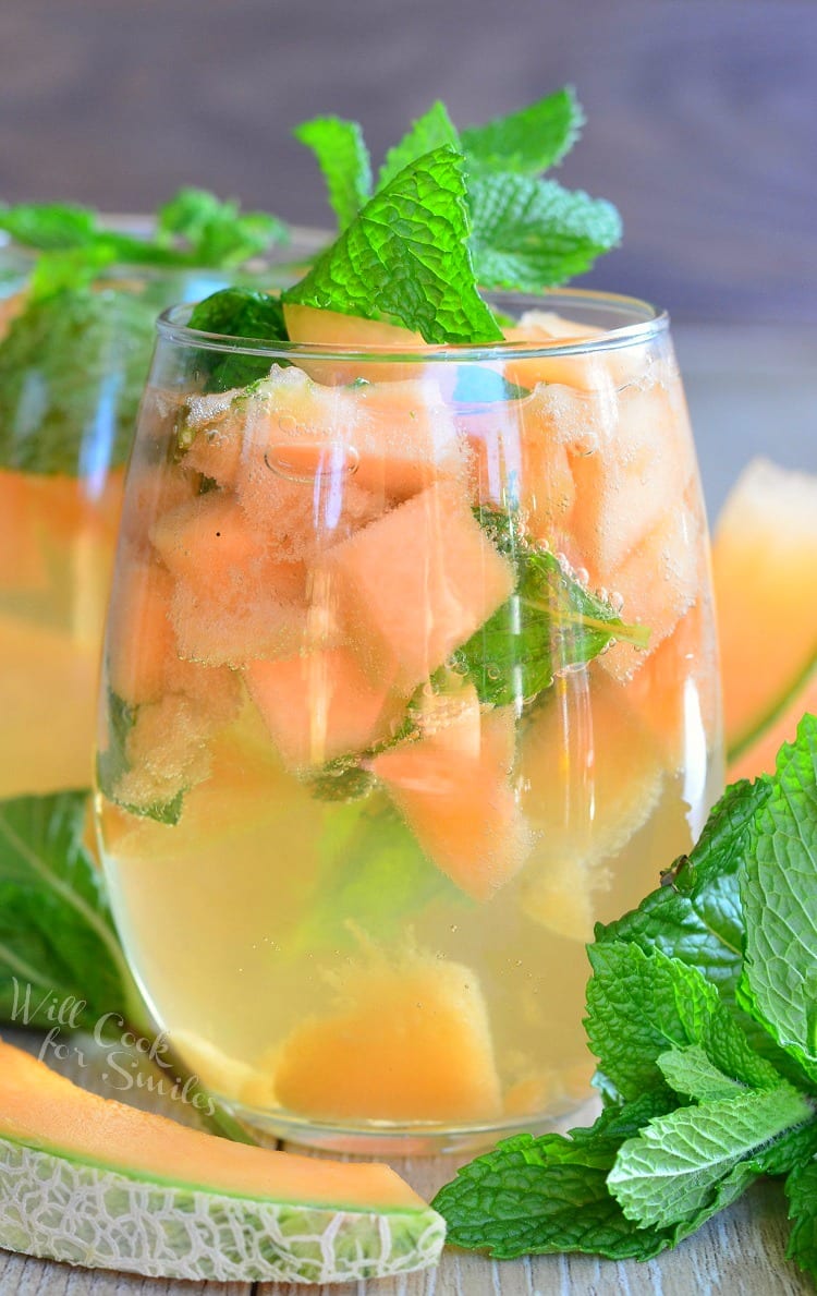 Melon Mint Wine Spritzer with cantaloupe and mint in a stemless wine glass with mint on top as a garnish