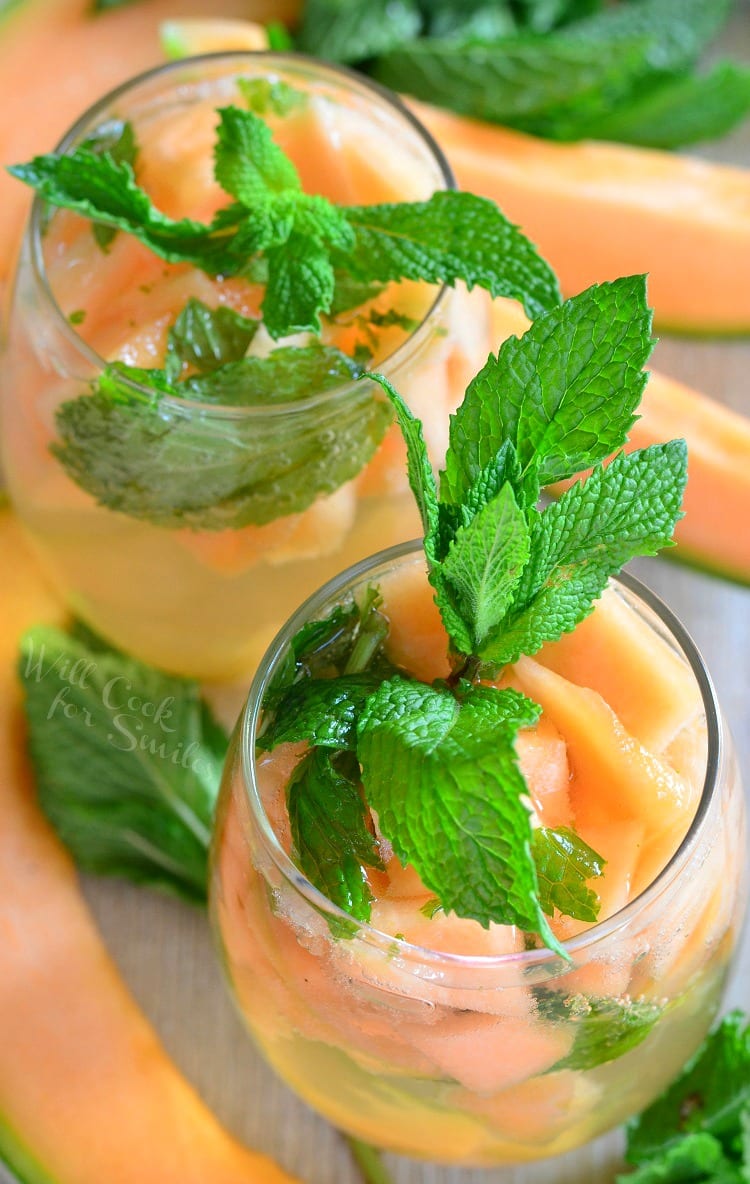 top view of Melon Mint Wine Spritzer with cantaloupe and mint in a stemless wine glass with mint on top as a garnish