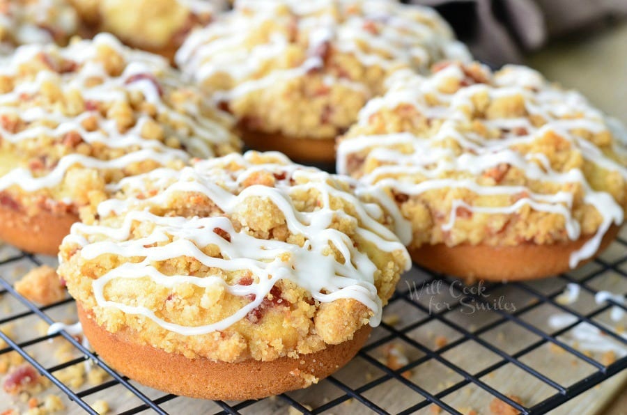 Bacon Crumb Doughnuts with icing and bacon on top on a cooling rack 