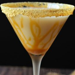 Martini glass filled with caramel cake martini and a graham cracker rim