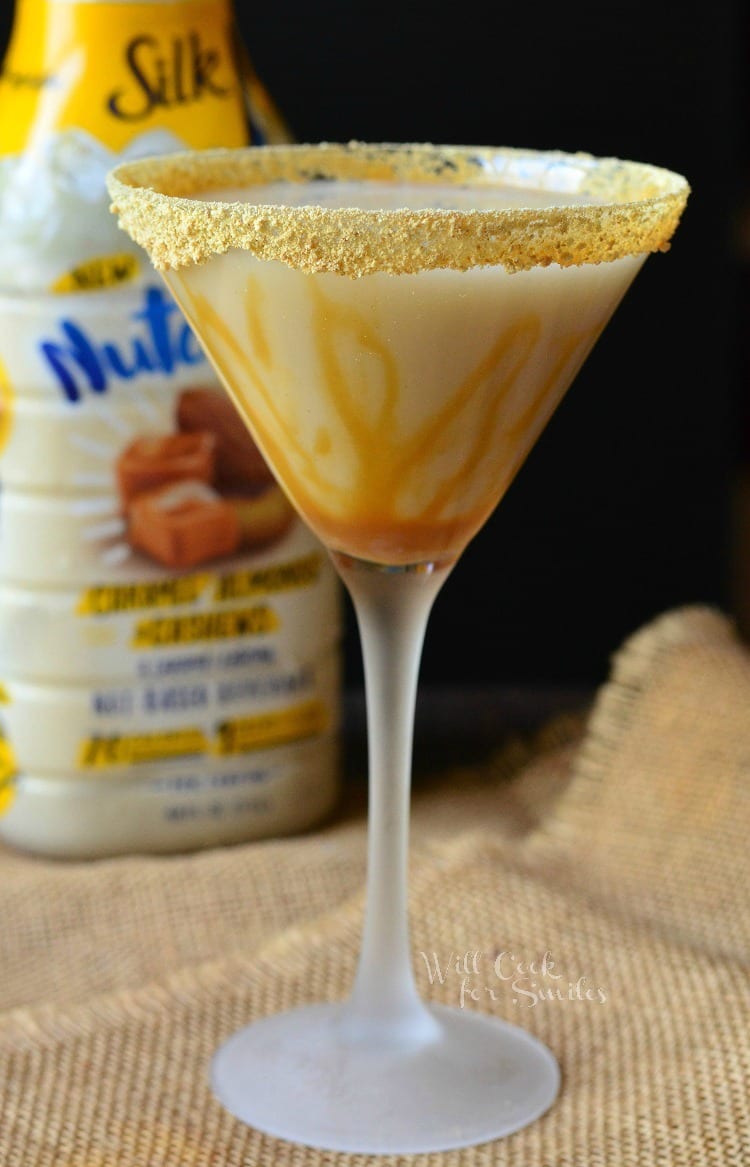 Caramel Cake Martini in a martini glass with caramel topping around the glass sitting on a burlap table cloth 