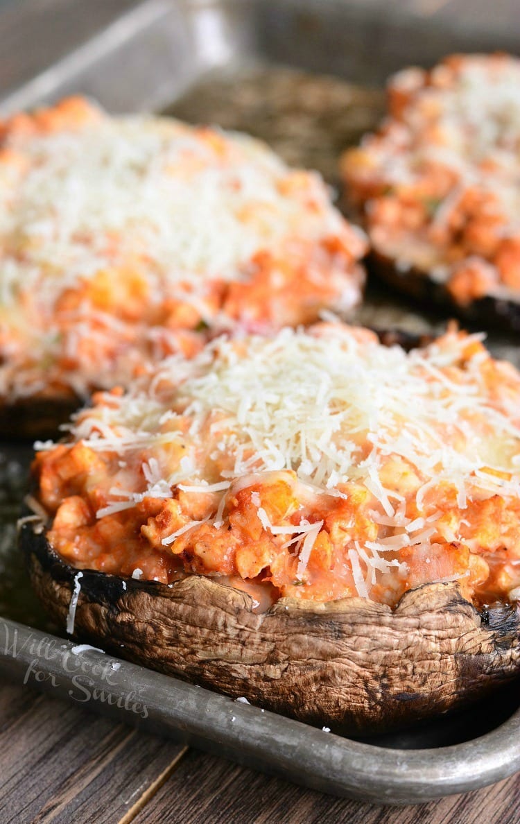 Chicken Parmesan Stuffed Portobello with cheese on top on a baking sheet 