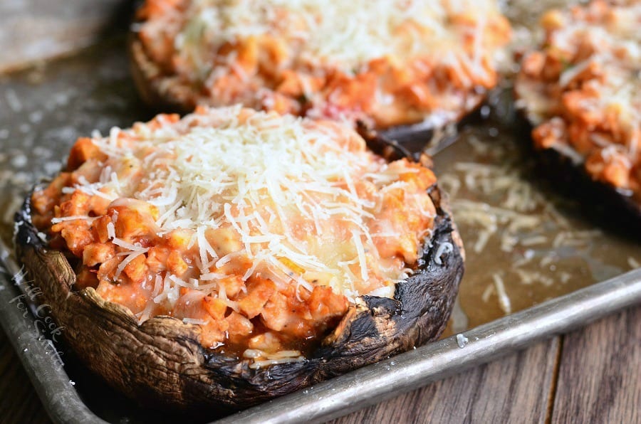 Chicken Parmesan Stuffed Portobello with cheese on top on a baking sheet 