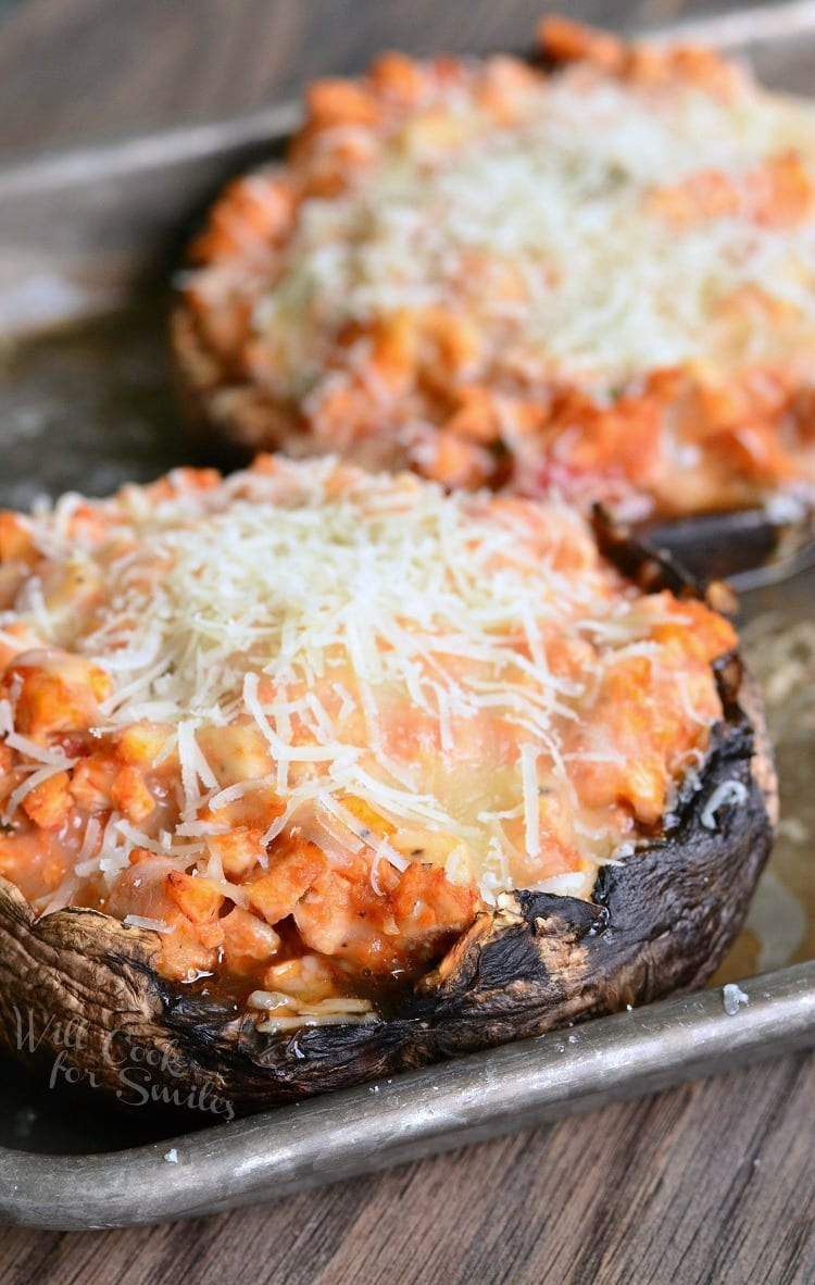 Chicken Parmesan Stuffed Portobello with cheese on top on a baking sheet 