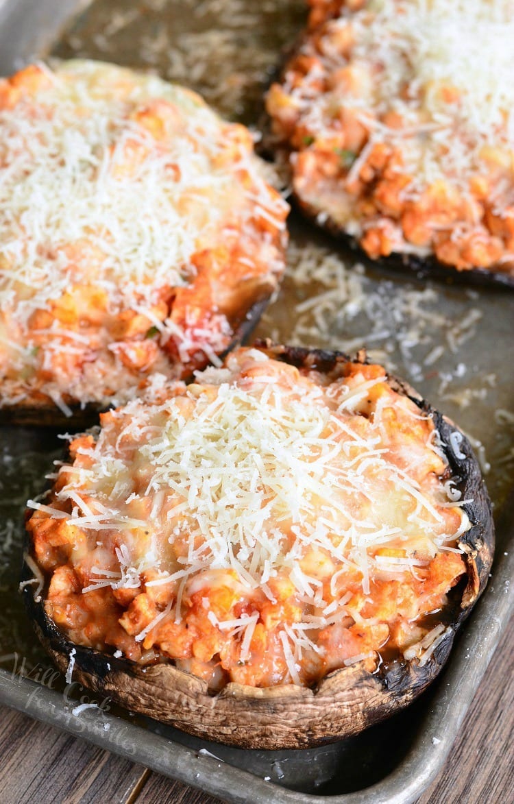 Chicken Parmesan Stuffed Portobello with cheese on top on a baking sheet 